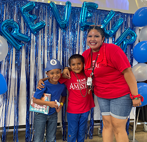 Two students celebrating with their teacher