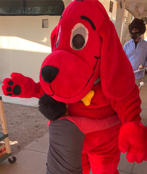 student hugging a Clifford mascot